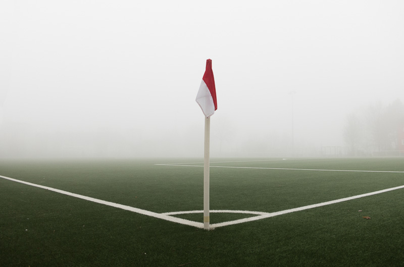 Eckfahne auf einem Fussballplatz mit Nebel