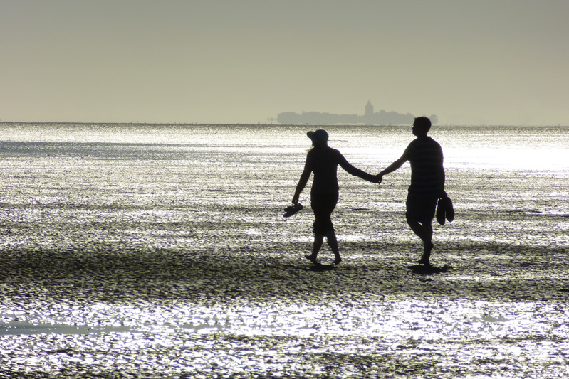 Paar am Strand, Abendstimmung, Hand in Hand