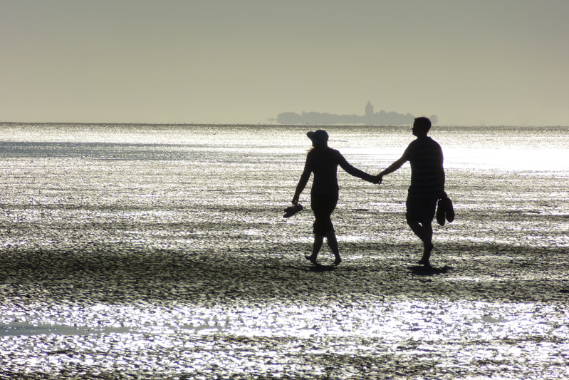 Paar am Strand, Abendstimmung, Hand in Hand