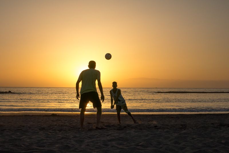 Volleyball am Strand mit Sonnenuntergang